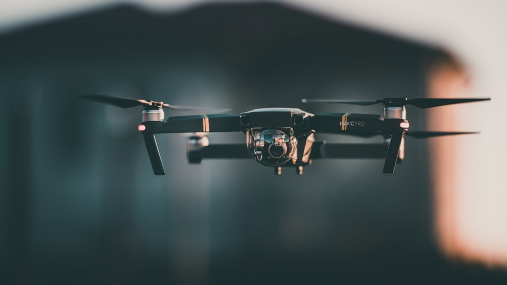 Drone with camera flying indoors for aerial footage.