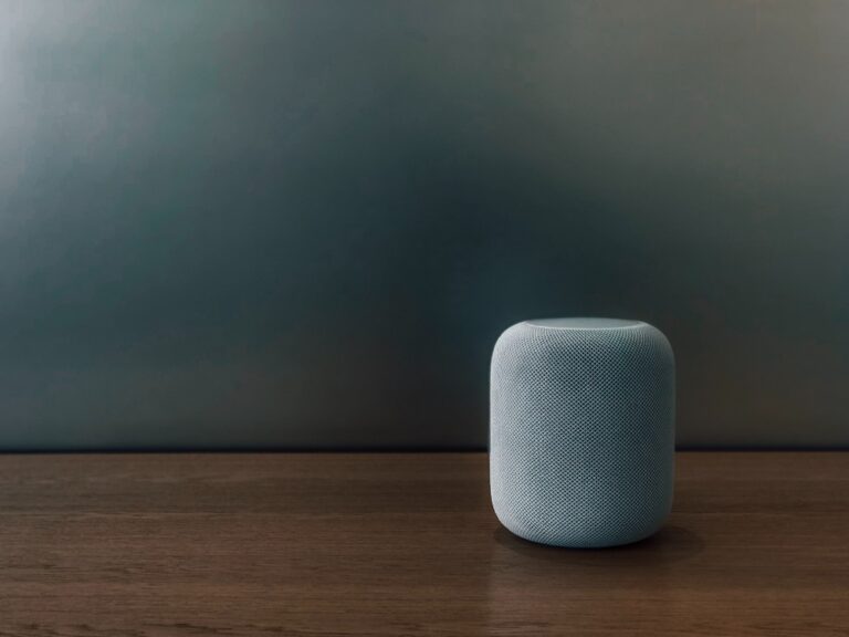 Smart speaker on wooden table in a sleek, modern interior setting.